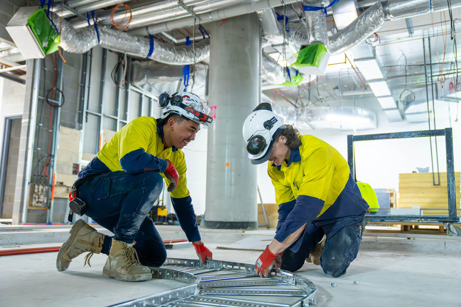 Electrical Trades Union members on jobsite at Footscray Hospital working on wiring tray