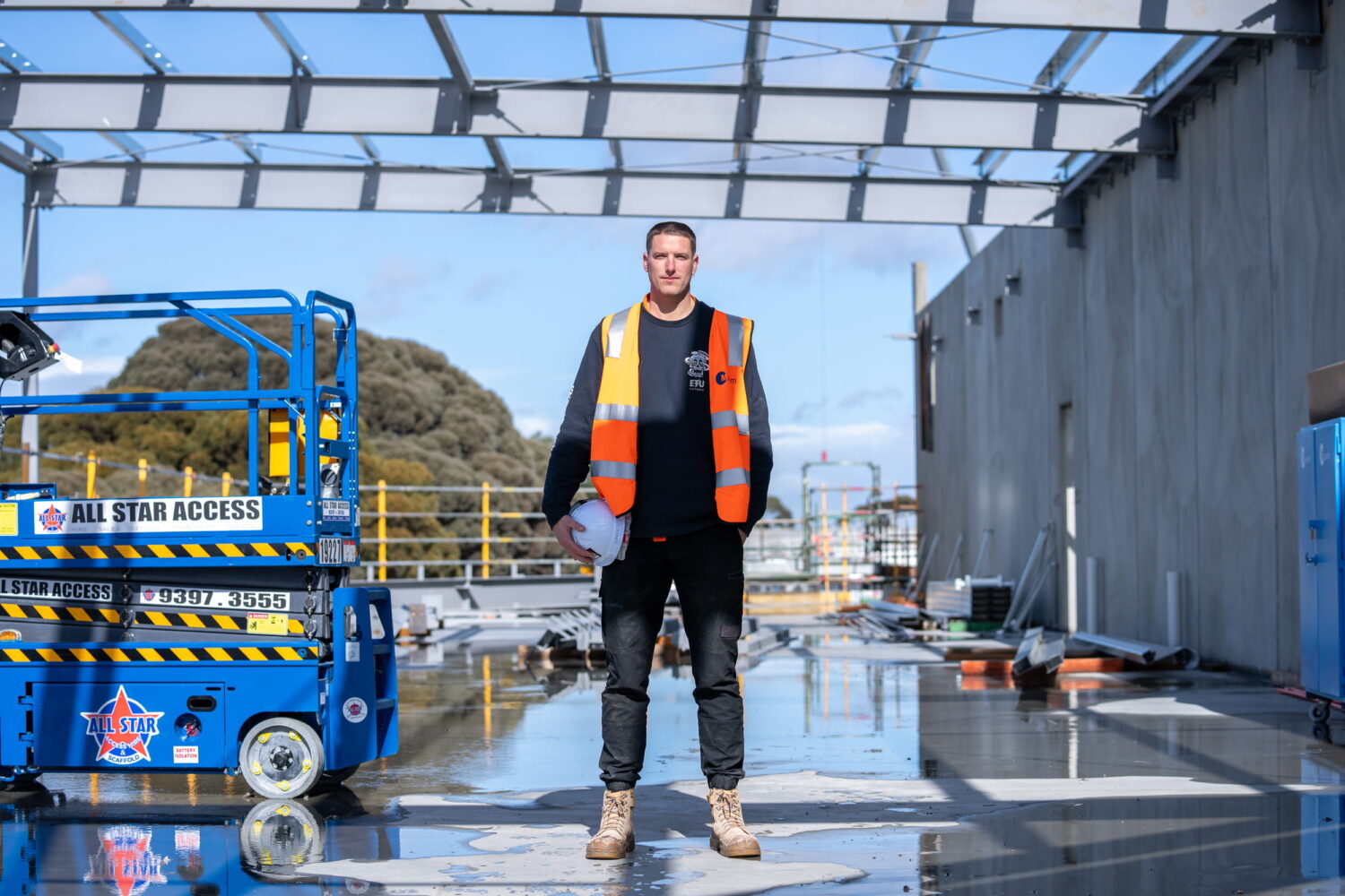 Electrical Trades Union of Victoria Organiser Chris Arkell on Jobsite next to scissor lift
